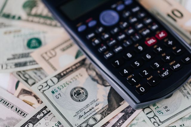 calculator on top of dollar bills